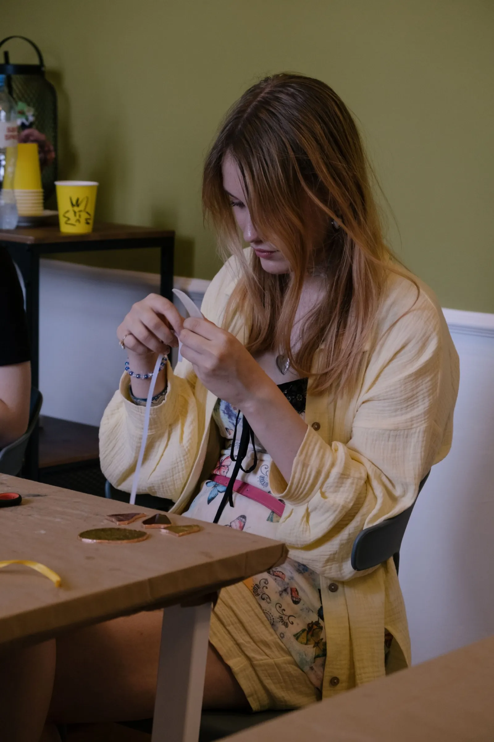 Участница оборачивает детали витража фольгой